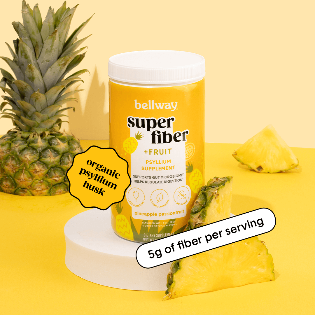 Bellway Super Fiber + Fruit pineapple passionfruit product image on a yellow background with pineapple slices. Text callouts read "organic psyllium husk" and "5g of fiber per serving."